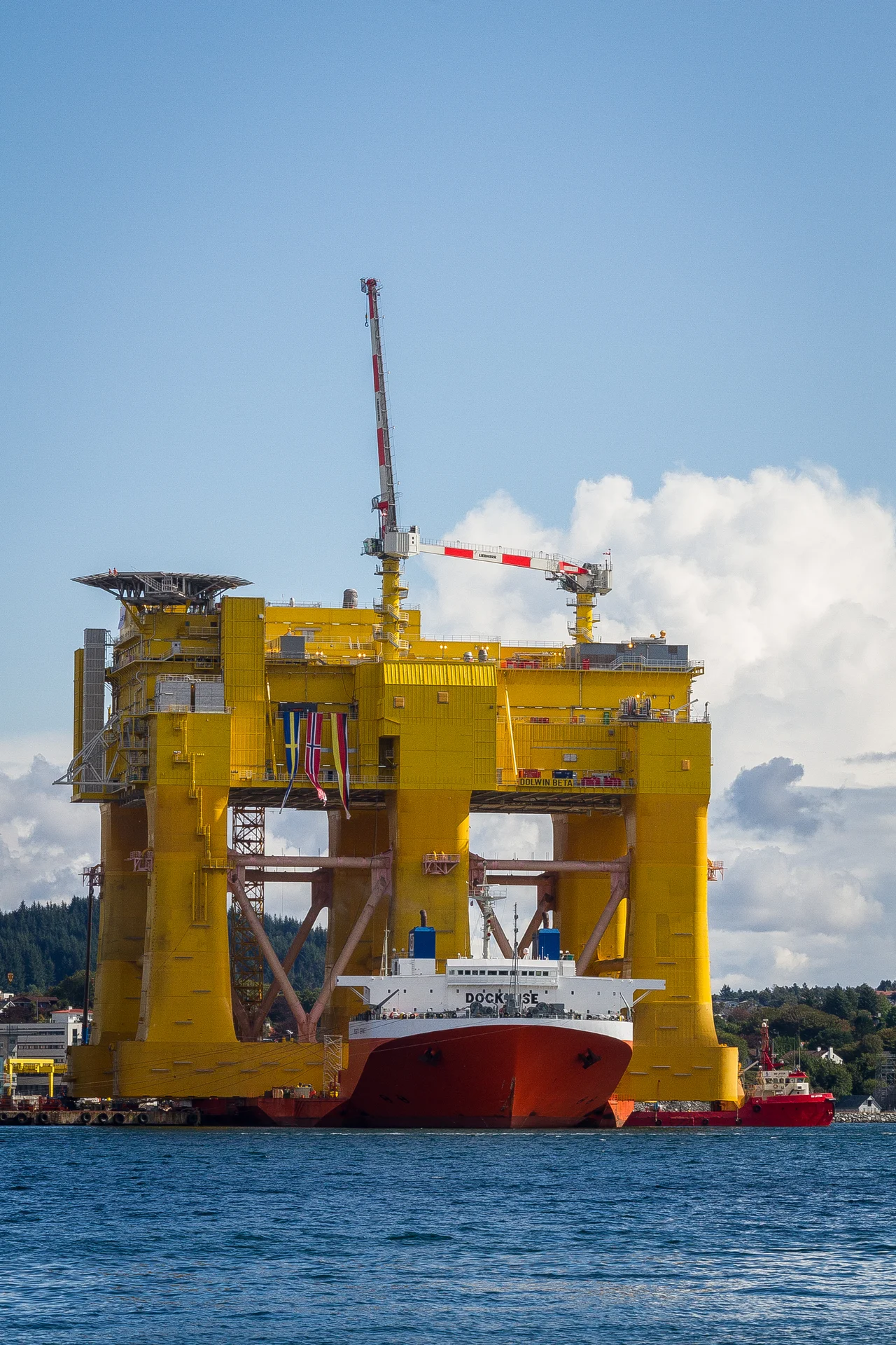 Mighty Servant 1 heavy-lift ship transporting DolWin beta offshore HVDC converter platform at Haugesund, Norway. 
Not that it is such a great shot in its own right, but I just had to take a picture of this! It is right outside my doorstep. Viewed from my house on the Karmøy island towards east and the city of Haugesund.

No - I am not playing with perspective or anything here. That ship (Mighty Servant 1) IS actually carrying this huge structure. The project is a cooperation between Aibel Norway and ABB. The structure itself has been built in Dubai, and is now at the Aibel yard in Haugesund for final equipment installations and testing. It has a capacity of 900 MW and will receive power from 240 wind turbines in the North Sea from Q2 2015.